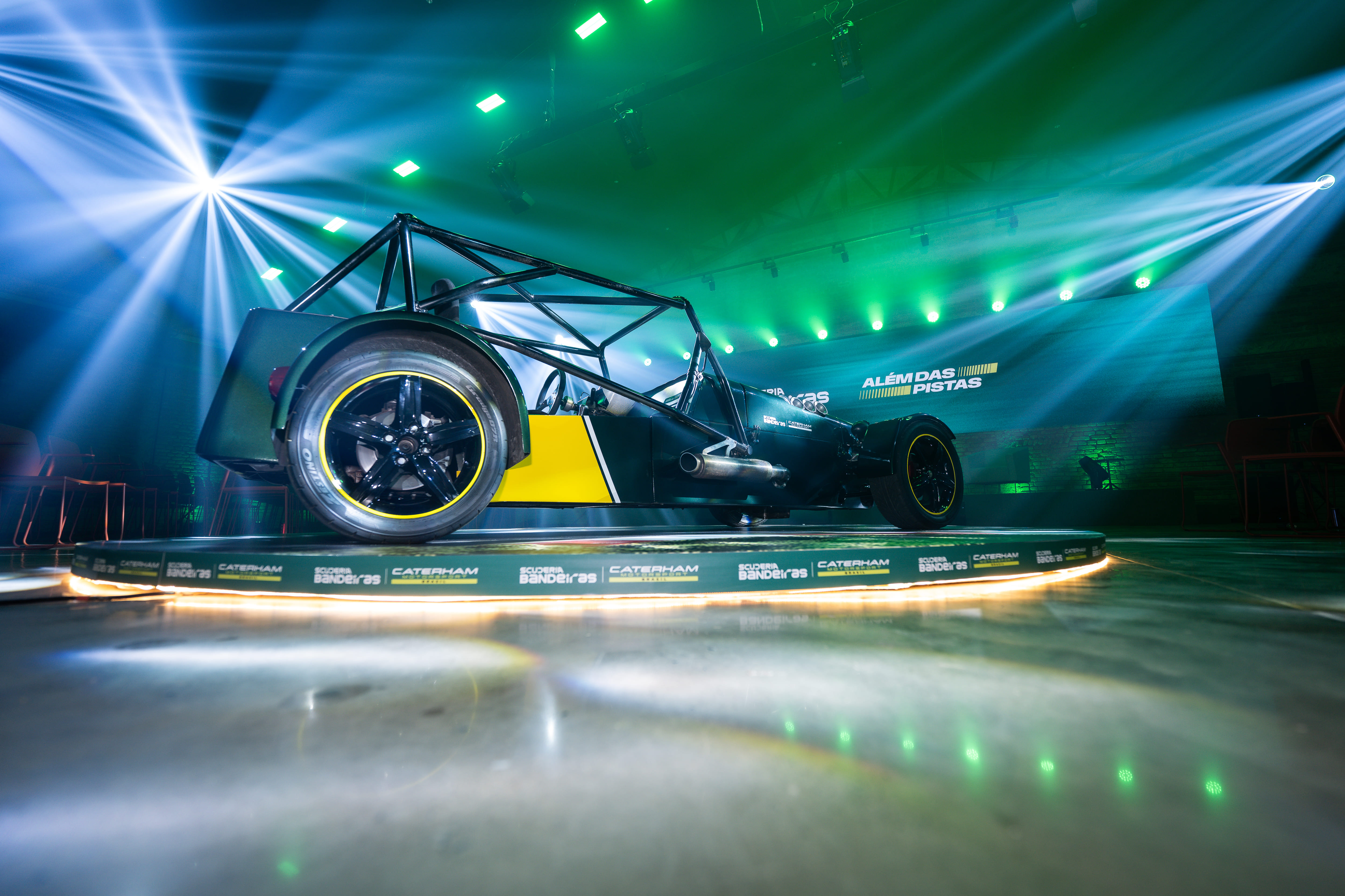 Caterham 7 em palco, lateral completa sob luzes verdes