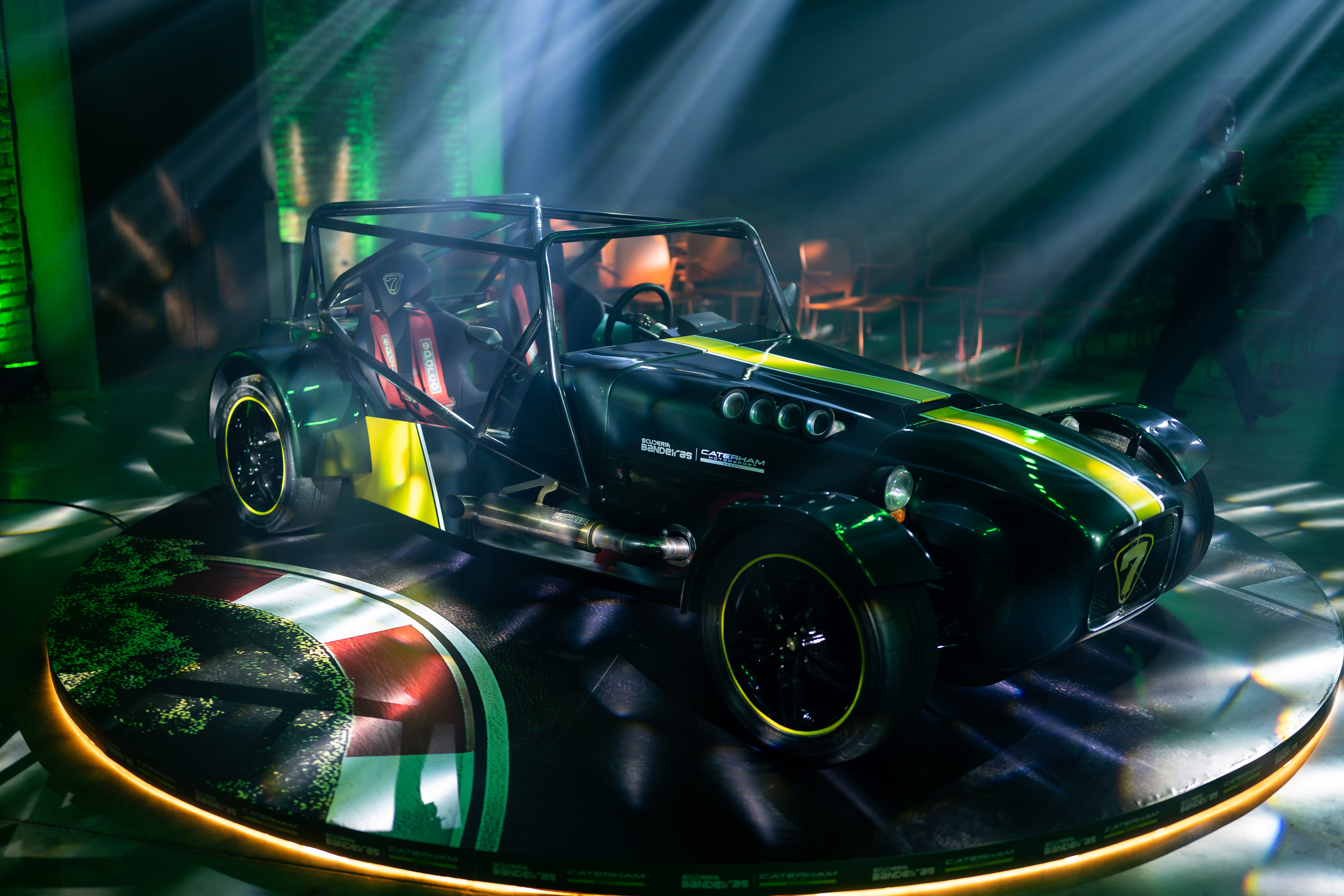 Caterham 7 em vista 3/4 frontal sobre plataforma