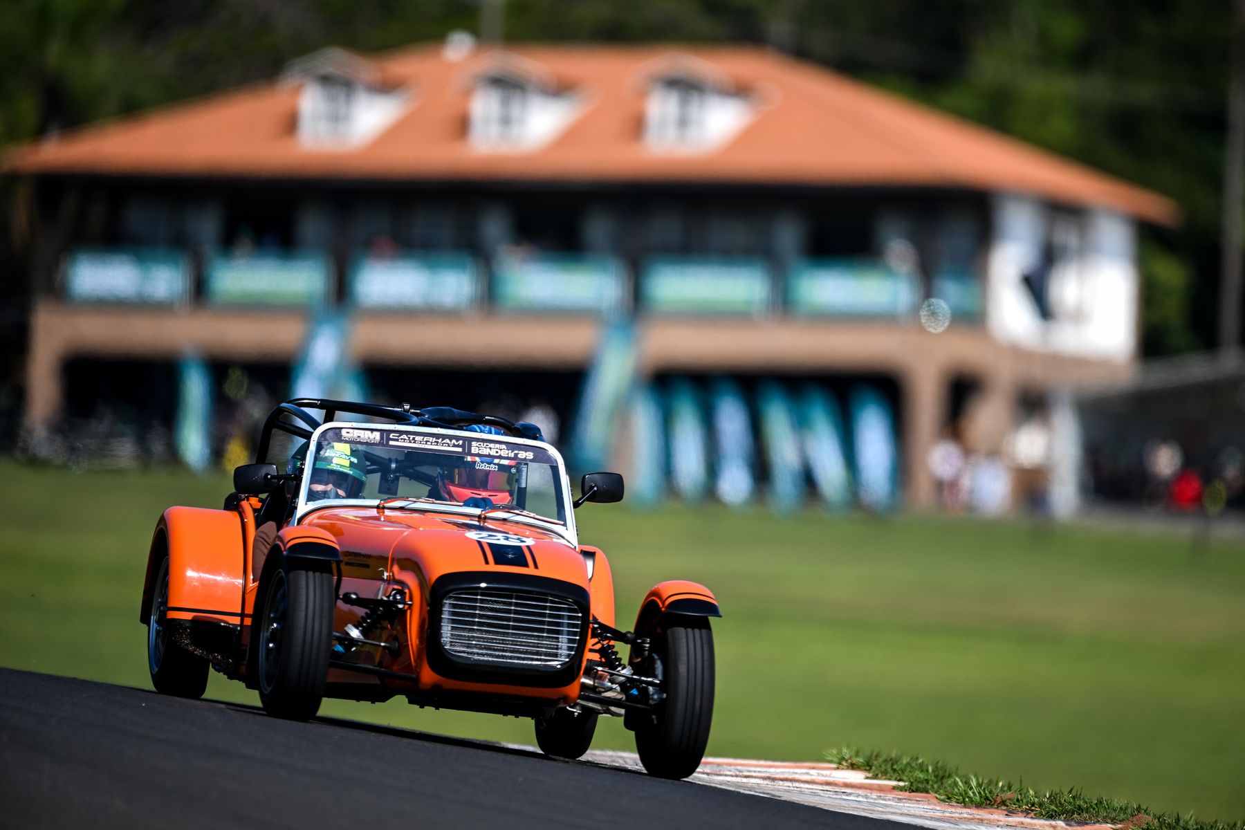 Caterham laranja na pista, em frente ao box